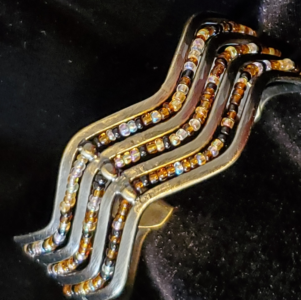 Bronze tone wavy cuff bracelet with brown seed beads